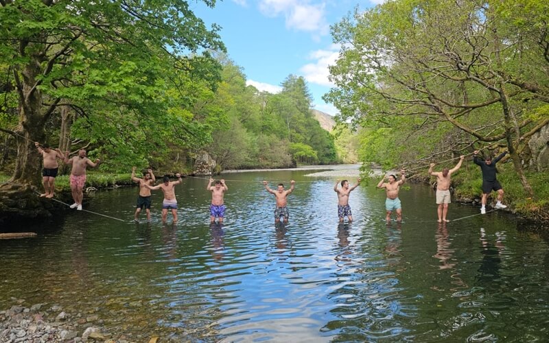 Men crossing a river on a rope bridge