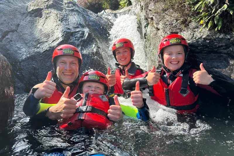 Ghyll scrambling family group giving the thumbs up