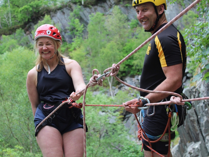Woman with Keswick Adventures instructor starting an abseil