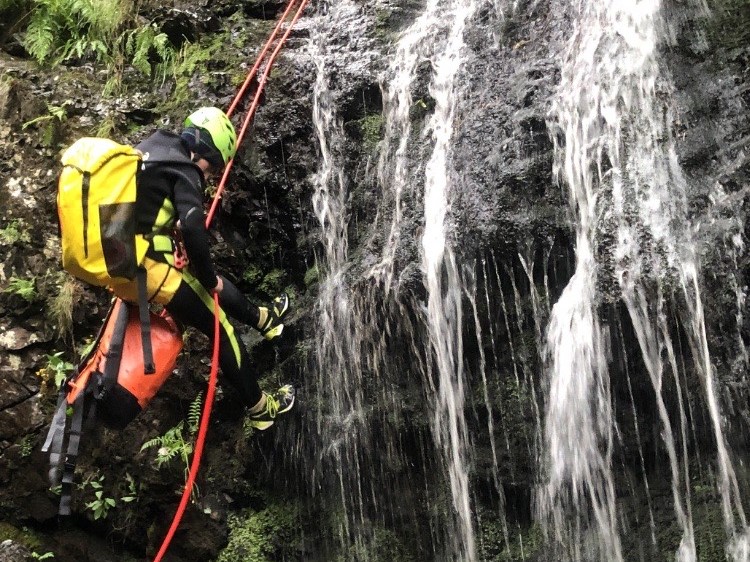 Keswick Adventures abseiling down a waterfall while canyoning