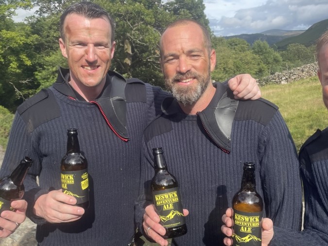 Two men drinking Keswick Adventures ale