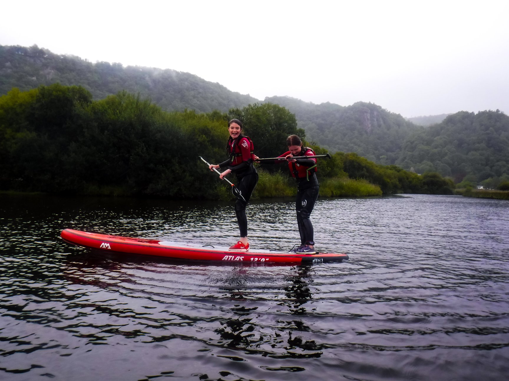 Teenagers paddle boarding in the Lake District