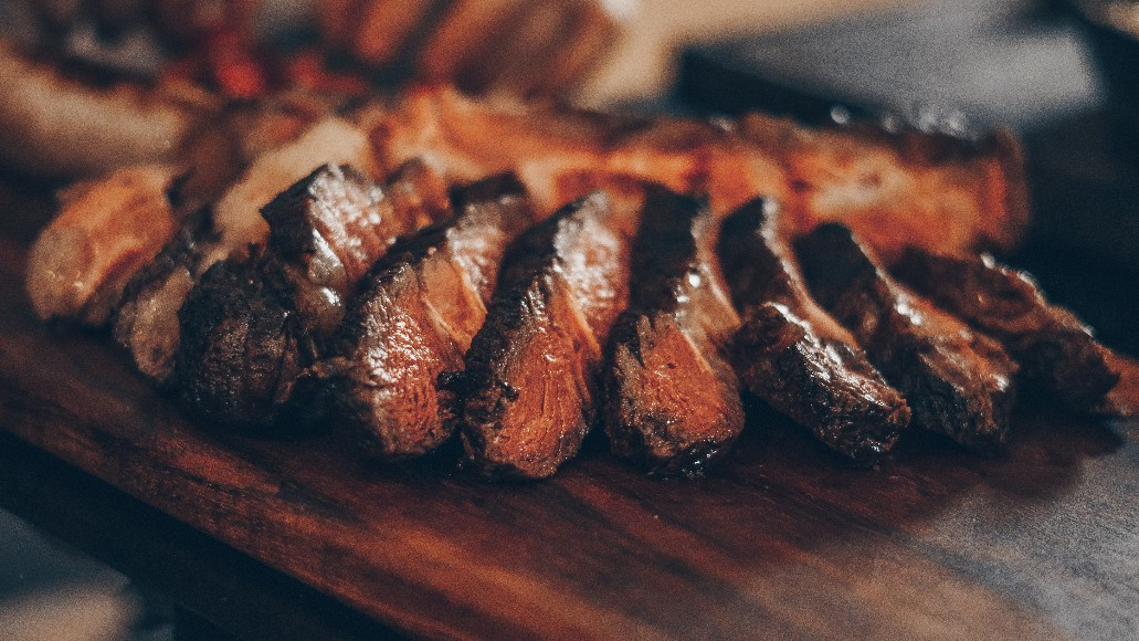 Medium-rare steak chopped into slices on a chopping board