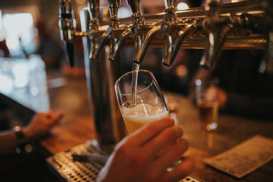 Person pouring a half pint from beer taps